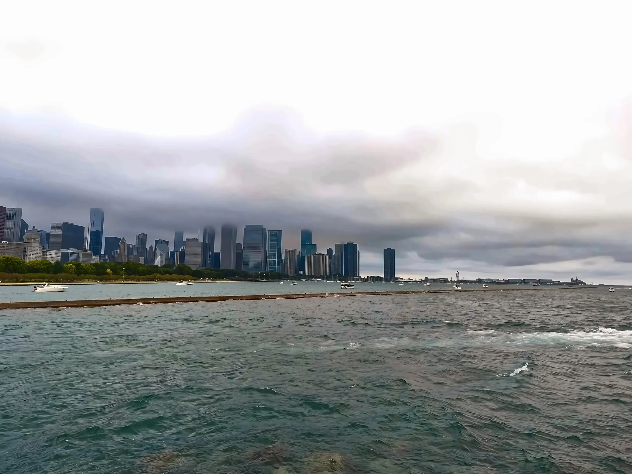 White boats dot Lake Michigan beneath Chicago’s cloud-covered skyline, with Navy Pier visible in the distance.