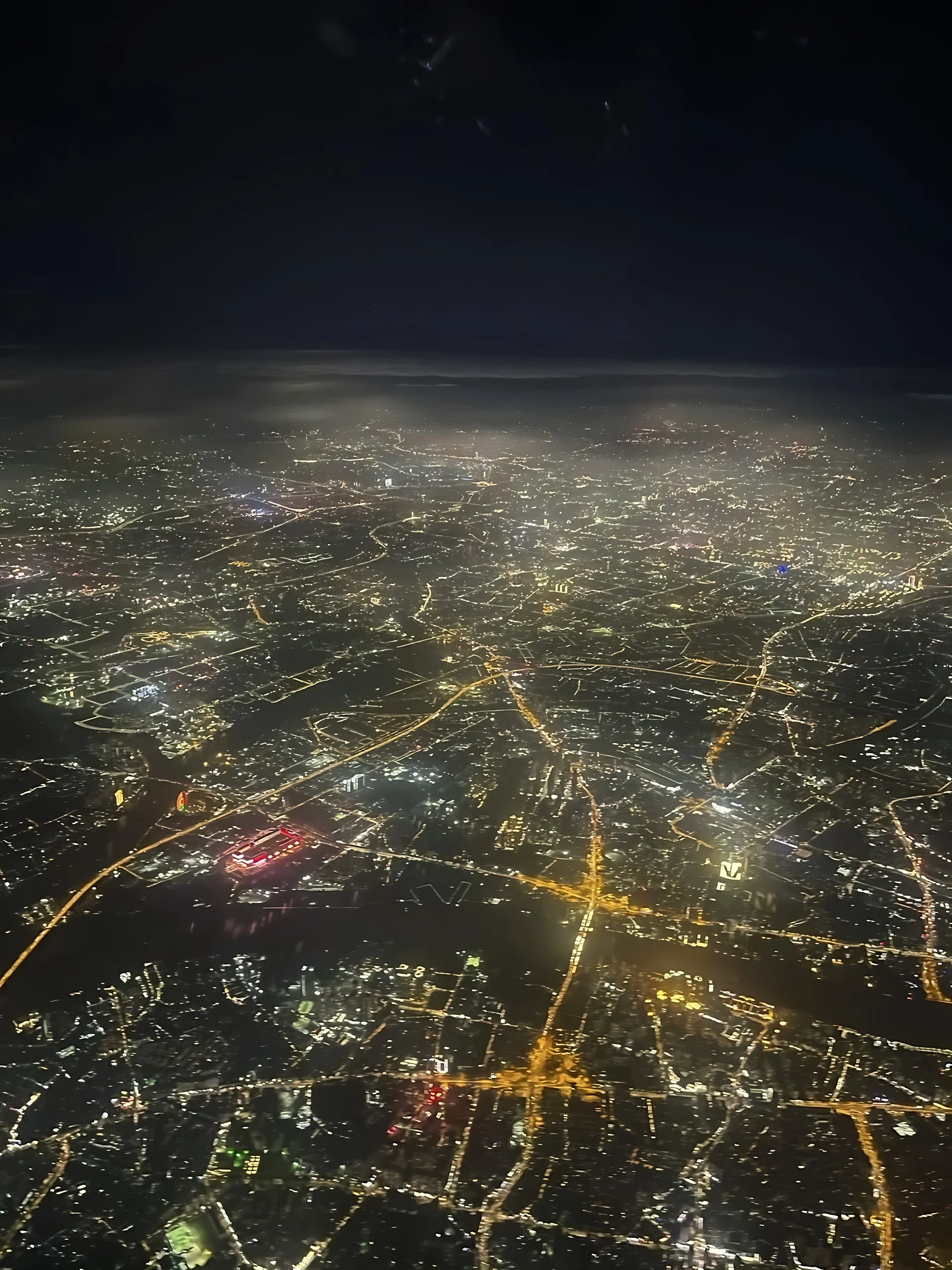 Guangzhou's city lights stretch into the distance, with glowing road networks, a broad river, and illuminated bridges below.